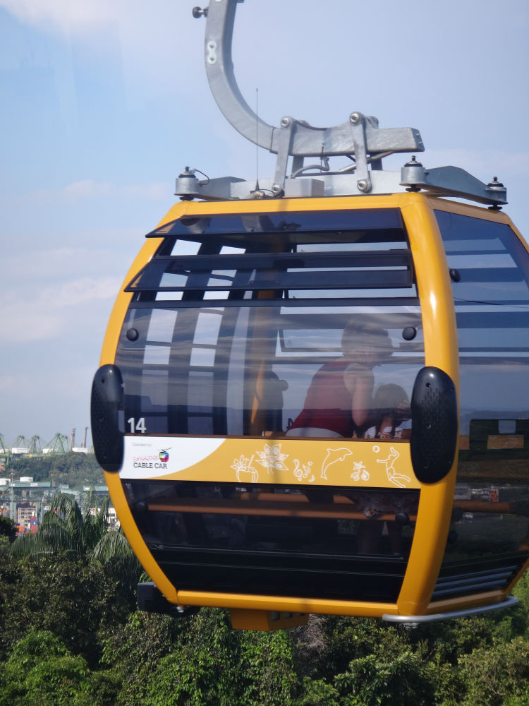A cable car cruising through the sky, taking its passengers with it on a sightseeing tour.