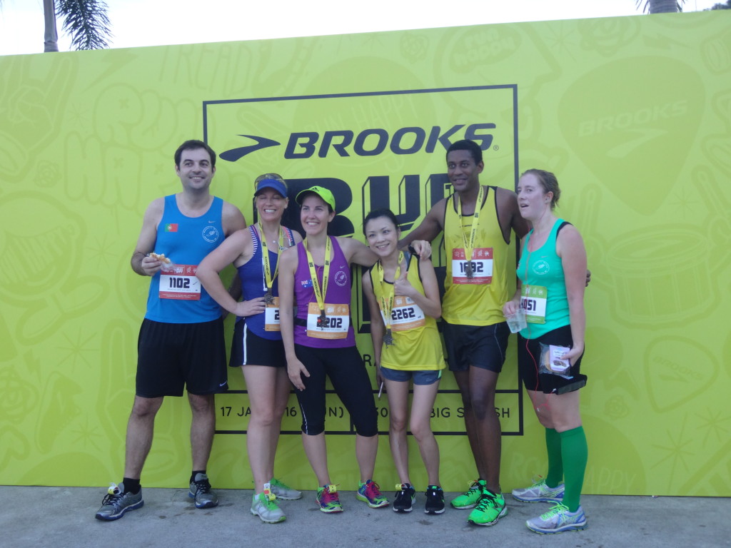 Runners take a photo at the Brooks signage for keepsake.