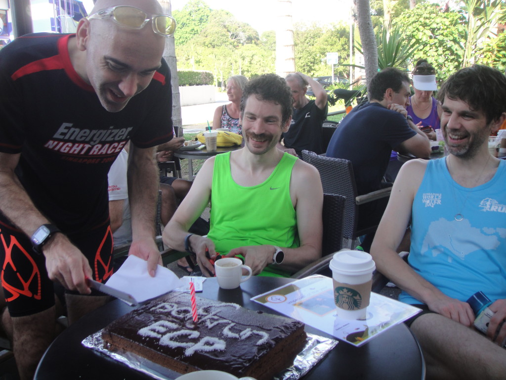 Event Director Dominic Watkins (left) cuts the birthday cake.