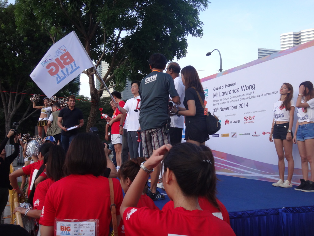 Media photographers clamour around the stage at the starting line.