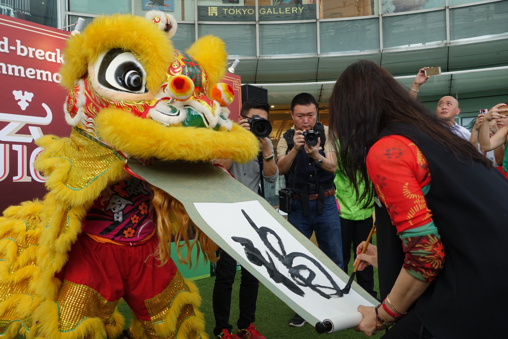 Chen also paints on a scroll dangling from the lion's mouth.