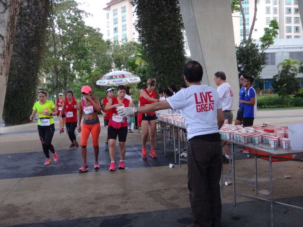 A runner accepts a drink from a hydration station during the race.