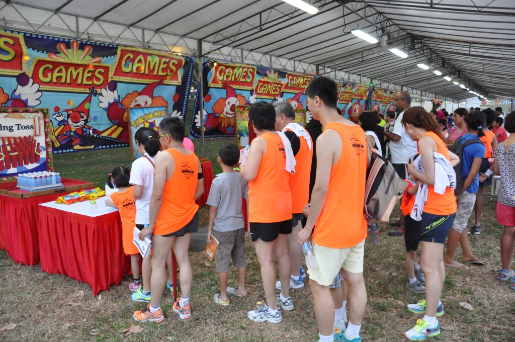 Runners queue up to play carnival games.