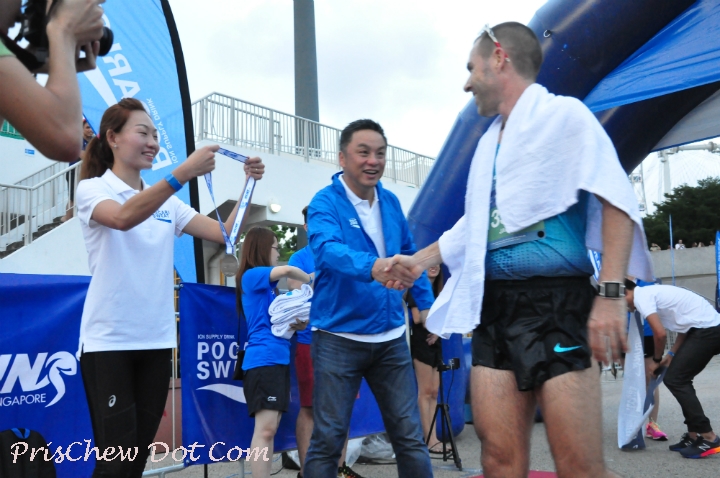 A winner is presented his finisher's medal by Neo Jie Shi, Pocari Sweat Singapore ambassador and Rio-bound marathoner.