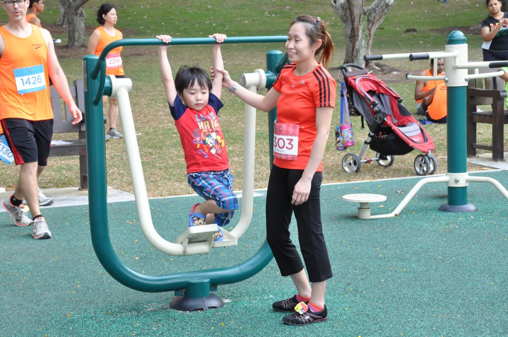 A runner and her young child enjoy the playground at Bedok Reservoir.