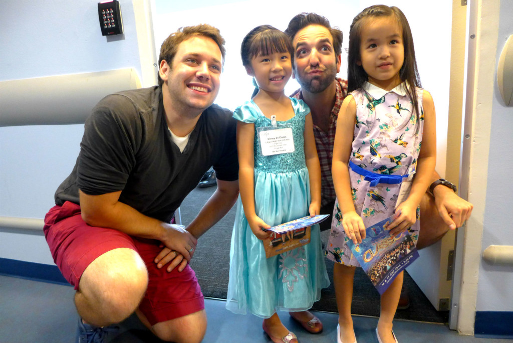 The male singers gamely pose for photos with young Disney fans.