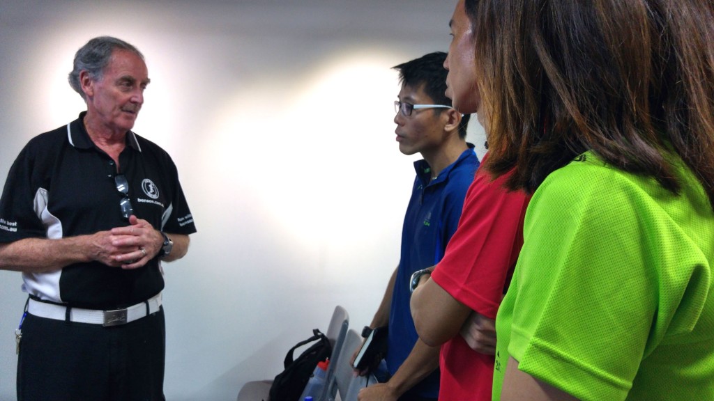 Runners crowd around Benson for some tips after the session.