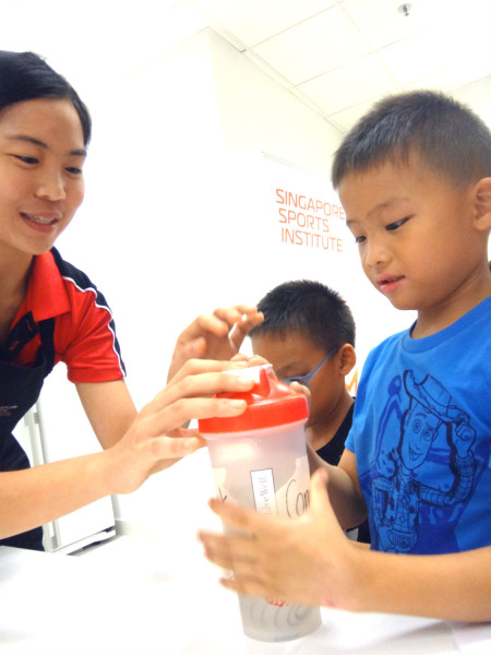 An SSI dietician (left) educates a young participant about sports drinks.